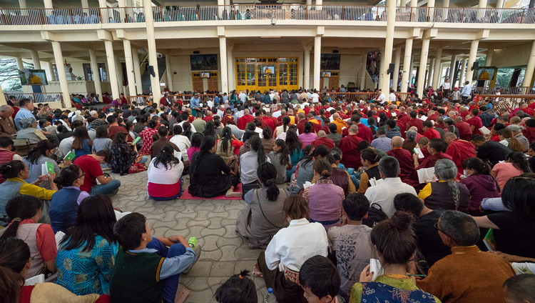 Некоторые из более чем 9000 верующих, собравшихся на учения Его Святейшества Далай-ламы для тибетской молодежи, смотрят трансляцию учений во дворе главного тибетского храма. Фото: Тензин Пунцок.