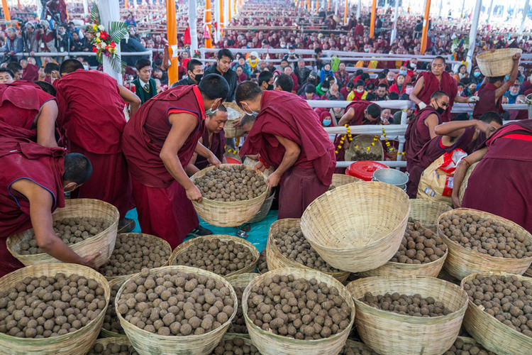 Монахи раздают пилюли долгой жизни более чем 200,000 участников 34-го посвящения Калачакры во время церемонии подношения Его Святейшеству Далай-ламе молебна о долгой жизни. Фото: Тензин Чойджор (офис ЕСДЛ)