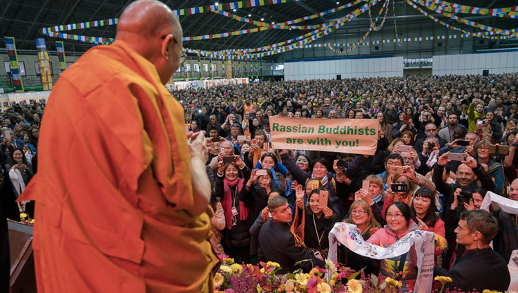 Его Святейшество Далай-лама приветствует 4,5-тысячную аудиторию в начале двухдневных учений в Риге. Фото: Тензин Чойджор (офис ЕСДЛ)