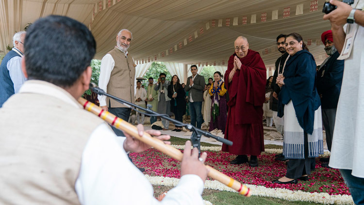 По прибытии на место учений, организованных по просьбе фонда  «Видьялока», Его Святейшество Далай-лама останавливается,  чтобы послушать музыканта, играющего на флейте. Фото: Тензин  Чойджор (офис ЕСДЛ)
