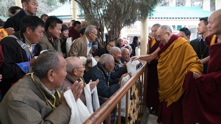 Его Святейшество Далай-лама приветствует верующих, направляясь в главный тибетский храм в начале первого дня учений. Фото: Тензин Чойджор (офис ЕСДЛ)