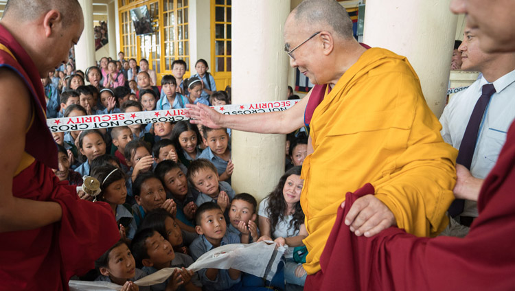 Его Святейшество Далай-лама приветствует юных тибетцев, покидая главный тибетский храм по завершении второго дня учений для тибетской молодежи. Фото: Тензин Чойджор (офис ЕСДЛ)