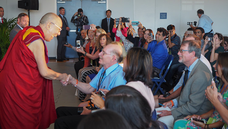 По прибытии на пресс-конференцию в Калифорнийском университете Сан-Диего Его Святейшество Далай-лама приветствует журналистов. Фото: Джереми Рассел (офис ЕСДЛ)