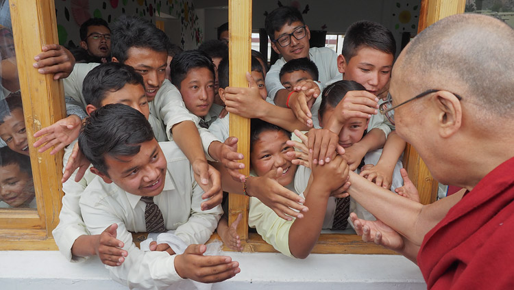 Ученики Ладакской публичной школы выглядывают из окна, чтобы пожать руку Его Святейшеству Далай-ламе. Фото: Джереми Рассел (офис ЕСДЛ)