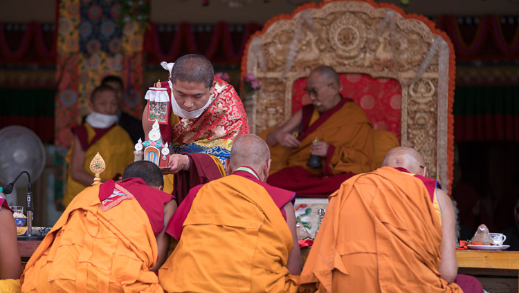 Один из помощников прикасается к головам старших монахов ритуальным предметом торма во время разрешения на практики Авалокитешвары, даруемого Его Святейшеством Далай-ламой. Фото: Тензин Чойджор (офис ЕСДЛ)