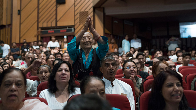 Пожилая тибетская женщина выражает почтение Его Святейшеству Далай-ламе, в то время как он обращается к тибетцам, собравшимся в конференц-зале Сири Форт. Фото: Тензин Чойджор (офис ЕСДЛ)