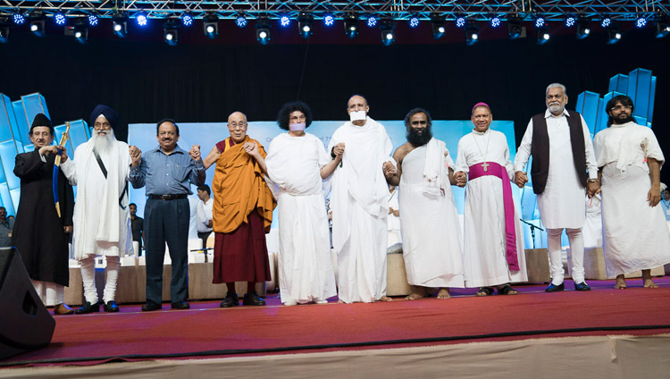 Его Святейшество Далай-лама и другие религиозные лидеры держатся за руки по завершении семинара «Мир и гармония во всем мире с опорой на межконфессиональный диалог». Фото: Тензин Чойджор (офис ЕСДЛ)