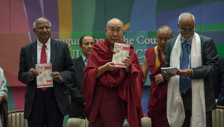 Его Святейшество Далай-лама представляет публике новый учебник в ходе церемонии запуска программы изучения светской этики в высших учебных заведениях. Фото: Тензин Чойджор (офис ЕСДЛ)