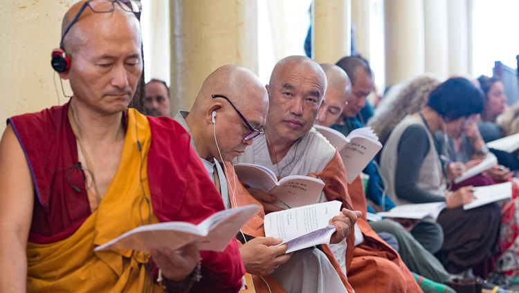 Верующие из стран Юго-Восточной Азии следят за текстом в ходе третьего дня учений Его Святейшества Далай-ламы. Фото: Тензин Чойджор (офис ЕСДЛ)
