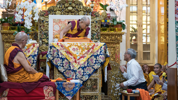 Переводчик на английский язык зачитывает Его Святейшеству Далай-ламе вопросы слушателей во время третьего дня учений, организованных по просьбе буддистов из Юго-Восточной Азии. Фото: Тензин Пунцок (офис ЕСДЛ) 