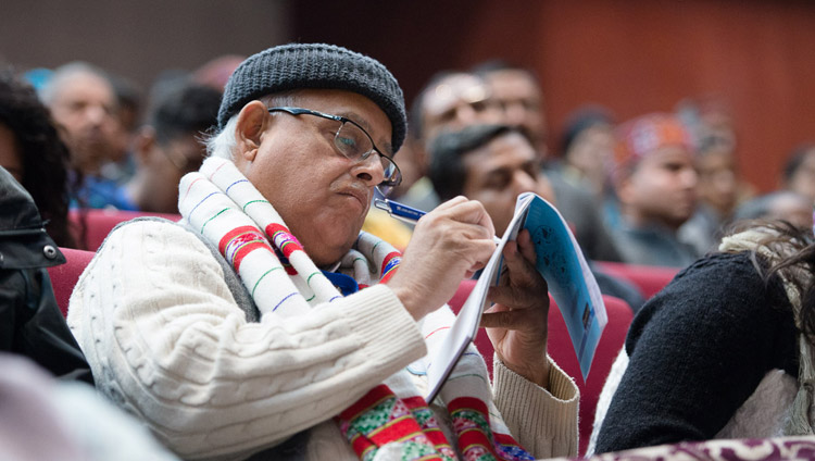 Один из слушателей делает записи во время выступления Его Святейшества Далай-лама на конференции по вопросам мира. Фото: Лобсанг Церинг.