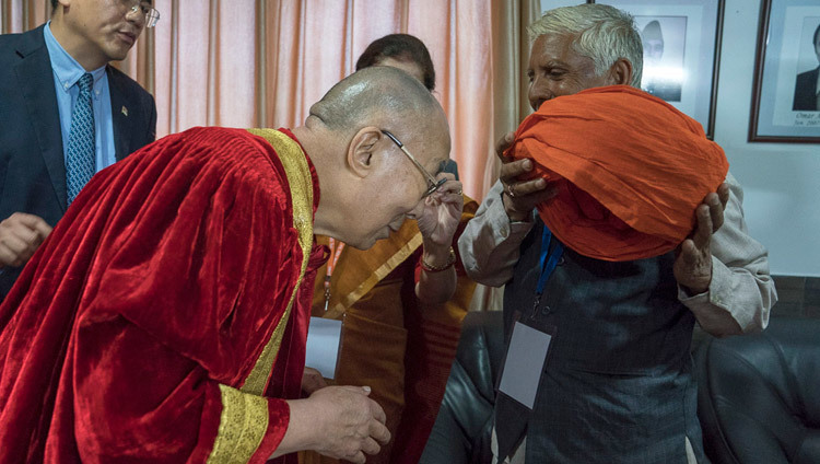 Его Святейшество Далай-лама надевает университетскую мантию и тюрбан перед началом 1-й церемонии вручения дипломов в Центральном университете Джамму. Фото: Тензин Чойджор.