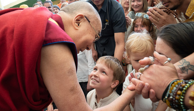Его Святейшество Далай-лама приветствует юных участников встречи перед тем, как сфотографироваться с ними и другими туристами, прибывшими из разных стран мира. Фото: Тензин Чойджор.