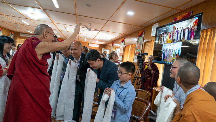 Его Святейшество Далай-лама машет рукой буддистам из Ханоя, Хошимина и Хайфона, принимающим участие во встрече посредством прямой трансляции через интернет. Фото: Тензин Чойджор.