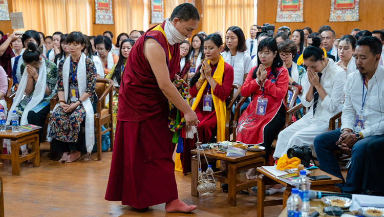 Монах проводит ритуальное очищение благовониями, в то время как Его Святейшество Далай-лама передает разрешение на практику Белого Манджушри в ходе второго дня встречи с буддистами из Вьетнама. Фото: Тензин Чойджор.