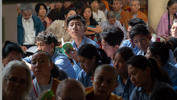Тибетские школьники и студенты, расположившиеся на веранде главного тибетского храма, слушают учения Его Святейшества Далай-ламы. Фото: Тензин Пунцок.