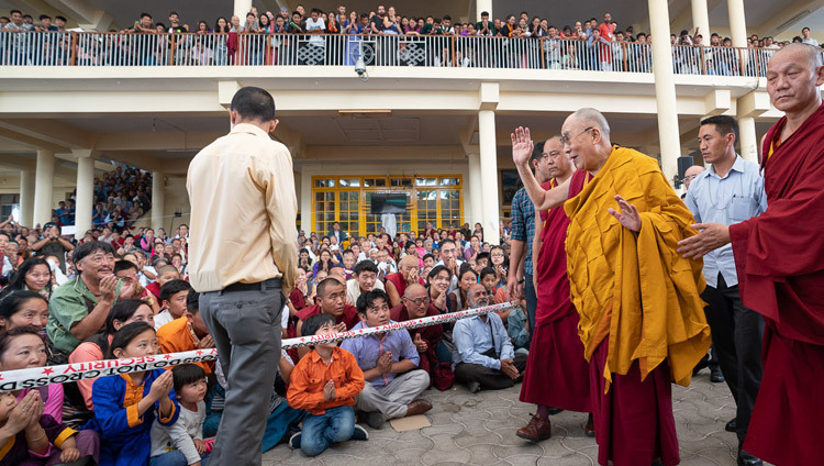 Возвращаясь в свою резиденцию по завершении учений для тибетской молодежи, Его Святейшество Далай-лама машет рукой верующим, собравшимся во дворе главного тибетского храма. Фото: Тензин Чойджор.