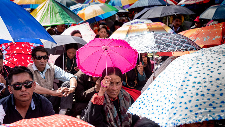 Верующие прячутся под зонтиками от палящих лучей солнца во время учений Его Святейшества Далай-ламы. Фото: Тензин Чойджор.