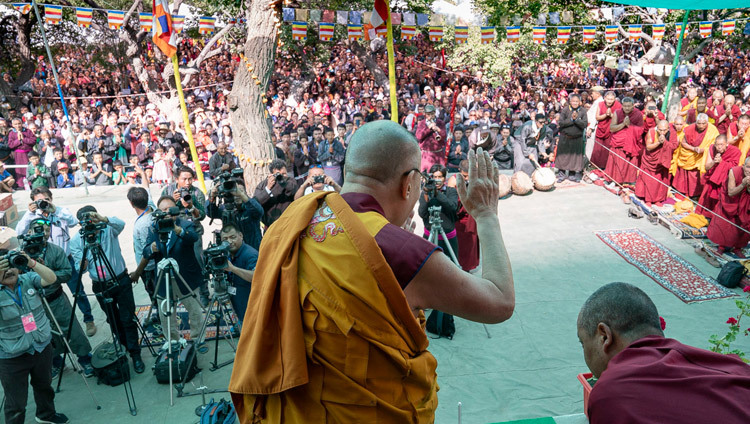 По прибытии на площадку для проведения учений монастыря Самстанлинг Его Святейшество Далай-лама приветствует верующих. Фото: Тензин Чойджор.