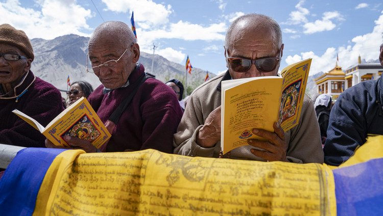 Верующие следят за текстом во время учений Его Святейшества Далай-ламы. Фото: Тензин Чойджор.