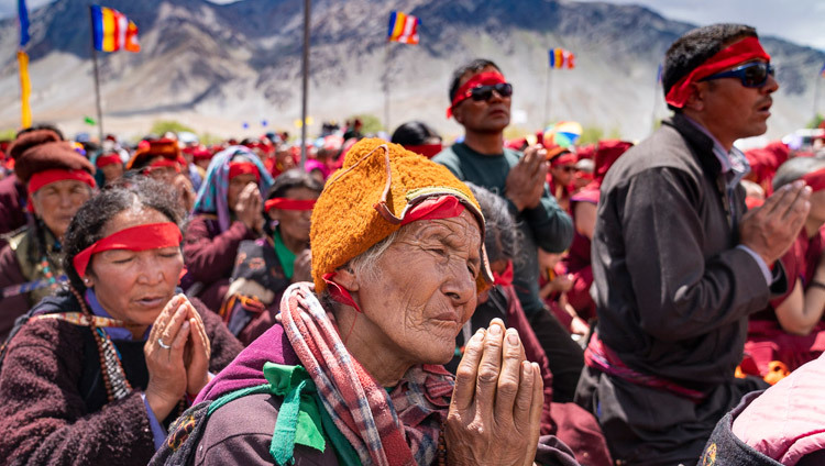 Надев красные ритуальные повязки, верующие слушают наставления Его Святейшества Далай-ламы во время благословения Авалокитешвары. Фото: Тензин Чойджор.