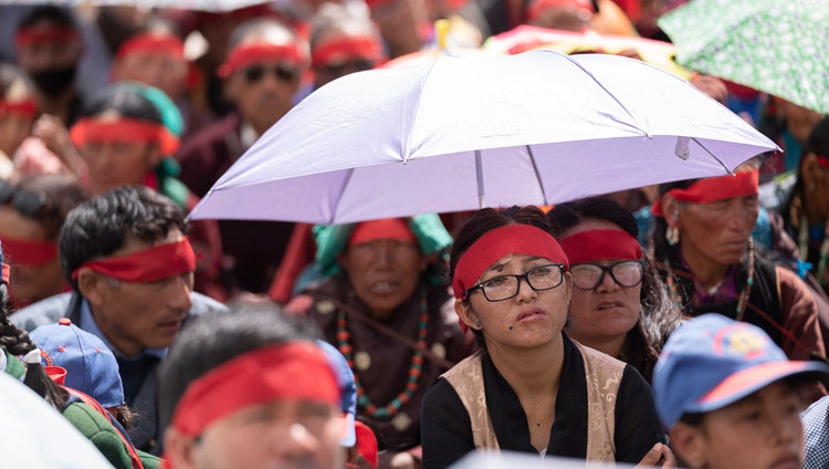 Некоторые из верующих прячутся от солнца под зонтиками во время благословения Авалокитешвары, даруемого Его Святейшеством Далай-ламой. Фото: Тензин Чойджор.