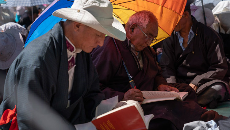 Верующие следят за текстом во время заключительного дня учений Его Святейшества Далай-ламы в Ле. Фото: Тензин Чойджор.