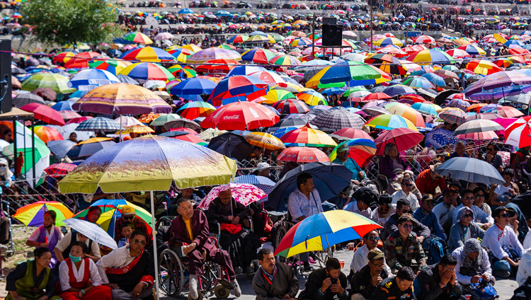 Верующие прячутся от солнца под зонтиками во время заключительного дня учений Его Святейшества Далай-ламы, на которые собралось более 30000 человек. Фото: Тензин Чойджор.
