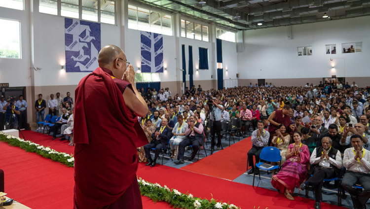 Поднявшись на сцену конференц-зала Института менеджмента Гоа, Его Святейшество Далай-лама приветствует слушателей. Санкелим, штат Гоа, Индия. Фото: Тензин Чойджор.
