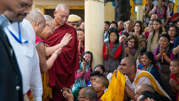 Покидая главный тибетский храм по завершении первого дня учений, Его Святейшество Далай-лама приветствует верующих, прибывших из разных стран мира. Фото: Тензин Чойджор.