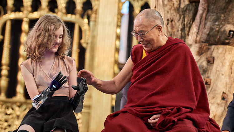 Его Святейшество Далай-лама рассматривает протезы рук Тилли Локи во время круглого стола «Робототехника и дистанционное присутствие», организованного в церкви Ньиве керк. Фото: Оливье Адам.