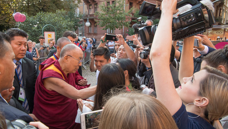 По прибытии в мэрию Гейдельберга Его Святейшество Далай-лама приветствует собравшихся там друзей и сторонников. Гейдельберг, Германия. Фото: Мануэль Бауэр.