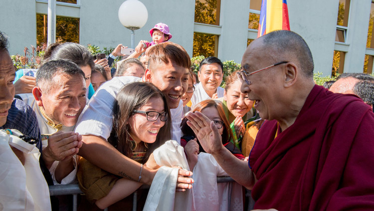 Его Святейшество Далай-лама приветствует тибетцев, собравшихся, чтобы встретить его по прибытии в отель. Цюрих, Швейцария. Фото: Мануэль Бауэр.