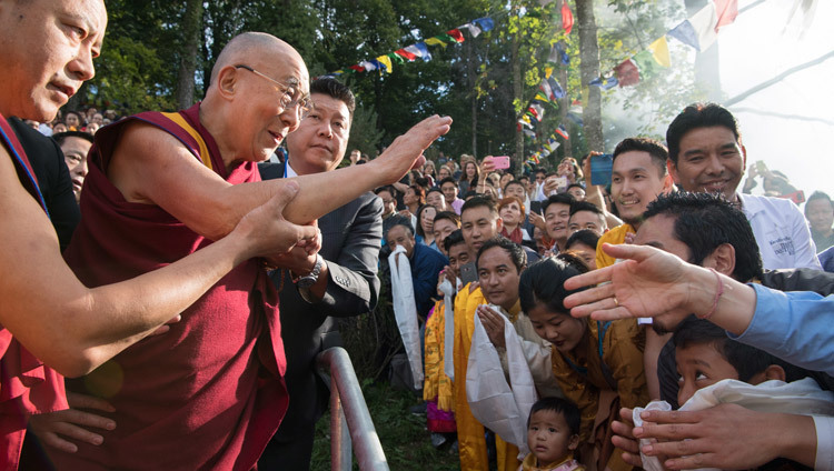 Его Святейшество Далай-лама приветствует тибетцев, собравшихся, чтобы встретить его по прибытии в Тибетский институт в Риконе. Фото: Мануэль Бауэр.