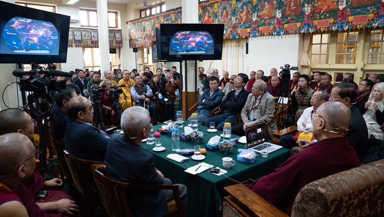 Его Святейшество Далай-лама, докладчики и слушатели смотрят презентацию профессора Ли Юаньчжэ по теме «Вызовы и возможности устойчивого развития планеты». Фото: дост. Тензин Джампхел.