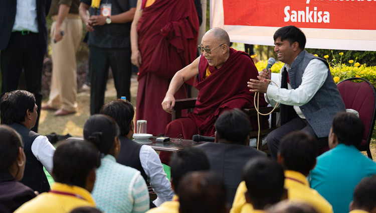 Его Святейшество Далай-лама дарует наставления волонтерам из Молодежного буддийского общества Индии, собравшимся на лужайке перед его отелем. Фото: Тензин Чойджор.
