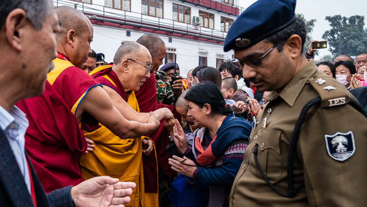 По дороге в храм Махабодхи Его Святейшество Далай-лама приветствует друзей и благожелателей. Фото: Тензин Чойджор.