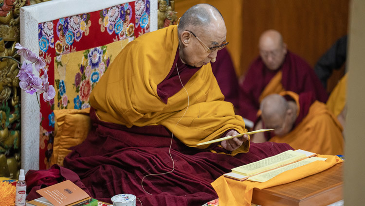 Его Святейшество Далай-лама читает текст во время второго дня учений по «Сущности Срединного пути» Бхававивеки. Фото: Тензин Чойджор.