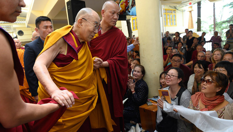 Его Святейшество Далай-лама приветствует слушателей, покидая главный тибетский храм по завершении первого дня учений для буддистов России. Фото: Тензин Чойджор.