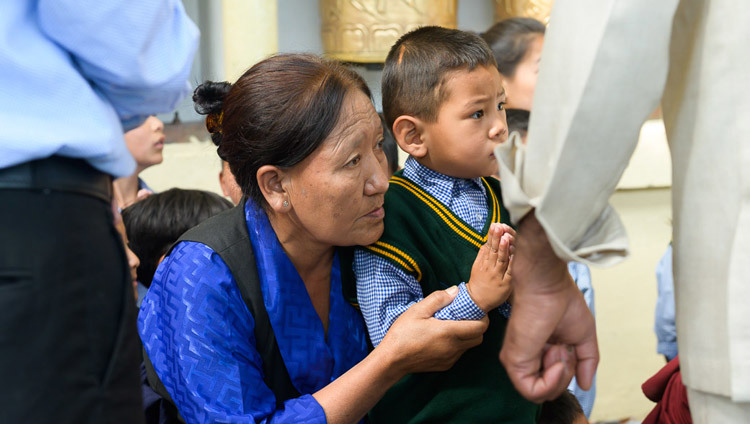Представители старшего и младшего поколений тибетцев смотрят, как Его Святейшество Далай-лама прибывает в главный тибетский храм, чтобы даровать учения по просьбе юных тибетцев. Фото: Тензин Чойджор.