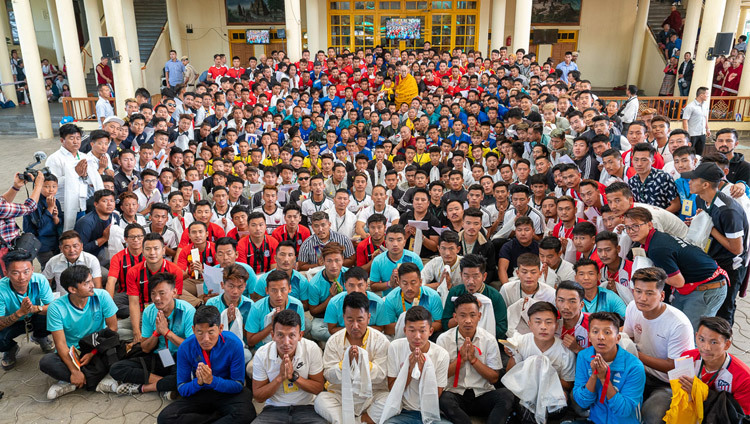 Его Святейшество Далай-лама позирует для фотографии с членами тибетских футбольных команд, участвующих в 25-м чемпионате на Золотой кубок памяти Гьялум Ченмо. Фото: Тензин Чойджор.