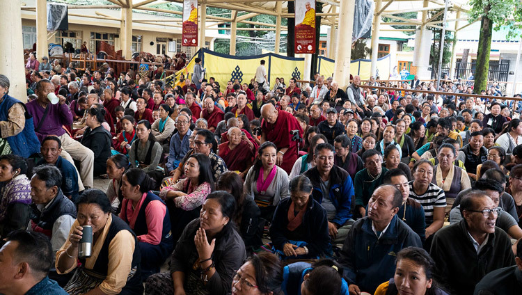 Верующие, собравшиеся во дворе главного тибетского храма, слушают учения Его Святейшества Далай-ламы. Фото: Маттео Пассигато.
