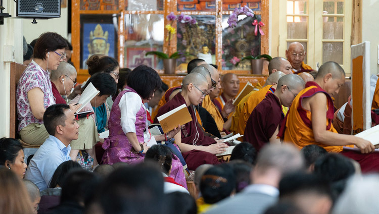 Слушатели следят за текстом, в то время как Его Святейшество Далай-лама читает сочинение Нагарджуны «Толкование бодхичитты». Фото: Тензин Чойджор.