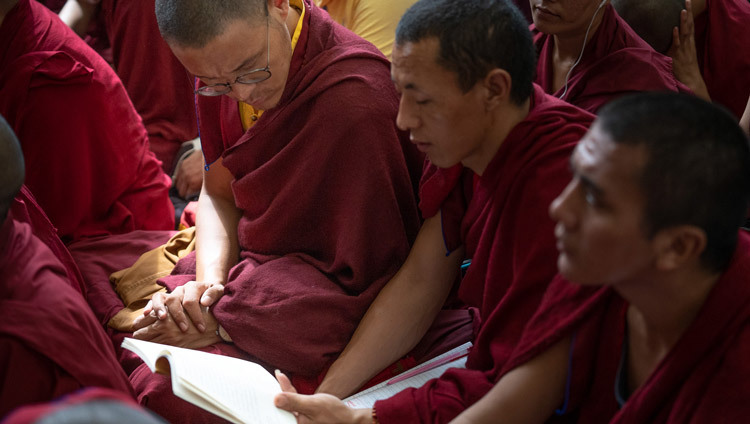 Монахи следят за текстом во время третьего дня учений Его Святейшества Далай-ламы, организованных по просьбе буддистов из стран Азии. Фото: Маттео Пассигато.