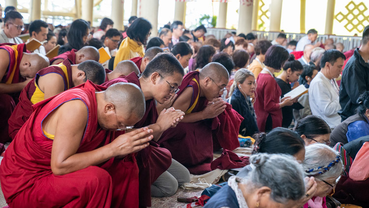 Верующие стоят на коленях во время церемонии зарождения бодхичитты, которую проводит Его Святейшество Далай-лама в завершение учений, организованных по просьбе буддистов из стран Азии. Фото: Маттео Пассигато.