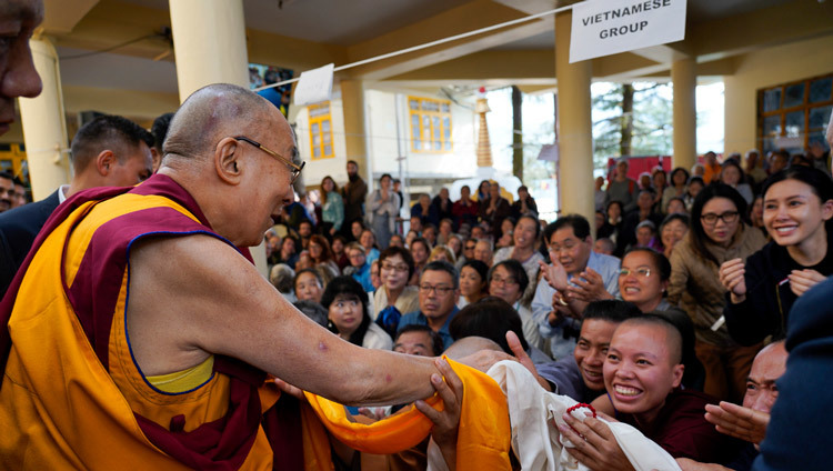 Покидая главный тибетский храм по завершении первого дня учений, Его Святейшество Далай-лама пожимает руки верующим. Фото: дост. Тензин Джампхел.