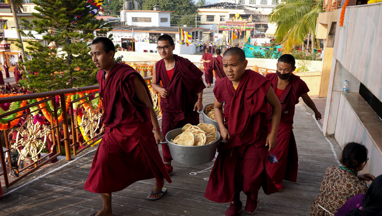 Юные монахи-волонтеры спешат угостить хлебными лепешками более 5000 верующих, собравшихся в монастыре Ганден Джангце на молебен о долголетии Его Святейшества Далай-ламы. Фото: Лобсанг Церинг.