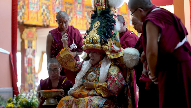Оракул Нечунга подбрасывает в воздух благословленные семена ячменя во время молебна о долголетии Его Святейшества Далай-ламы. Фото: Лобсанг Церинг.