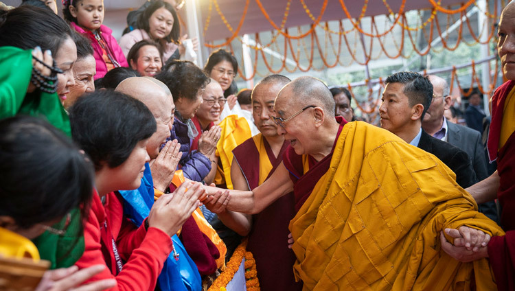 По прибытии на площадку Калачакры в Бодхгае Его Святейшество Далай-лама приветствует верующих. Фото: Тензин Чойджор.