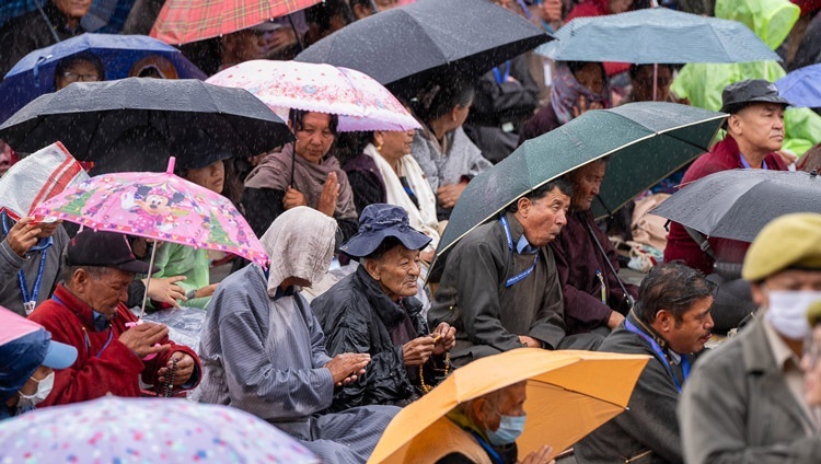 Слушатели, многие из которых укрываются под зонтиками от дождя, во время посвящения Авалокитешвары, даруемого Его Святейшеством Далай-ламой. Ле, Ладак, Индия. 23 июля 2023 г. Фото: Тензин Чойджор (офис ЕСДЛ).